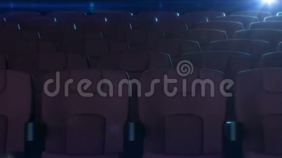 电影院大厅里一排排红色的椅子背景上闪烁着电影放映机灯红色座椅的三维动画视频的预览图