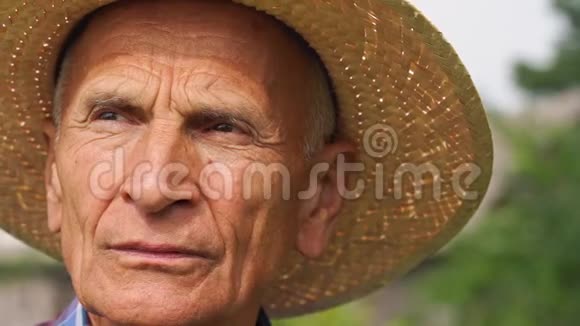 一个满脸皱纹的老人在花园里看风景视频的预览图