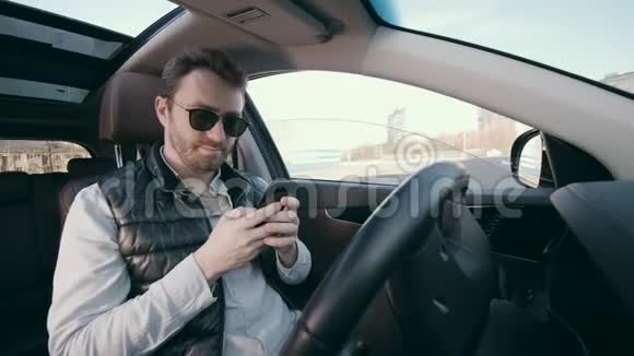 有智能手机的男性司机坐在自动车里视频的预览图
