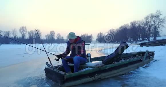 冬天渔夫从湖中的洞里钓鱼视频的预览图
