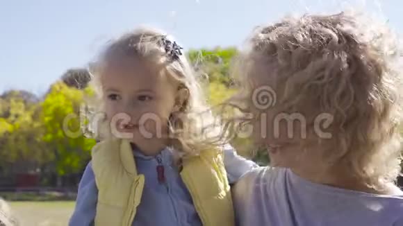 金发碧眼的女人手里拿着漂亮的白种人女孩微笑的母女站在视频的预览图