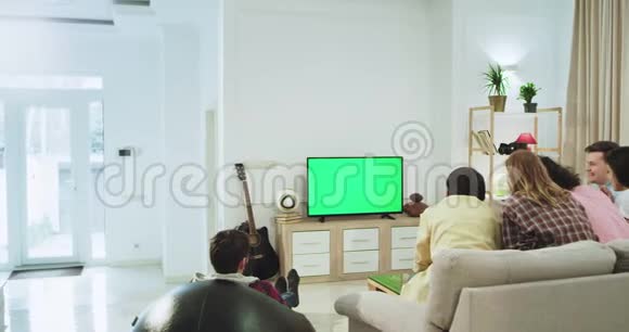 在现代宽敞的客厅里一群朋友坐在沙发上一边吃零食一边聊天视频的预览图