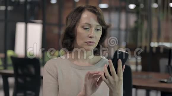 积极的老妇人使用智能手机应用程序视频的预览图
