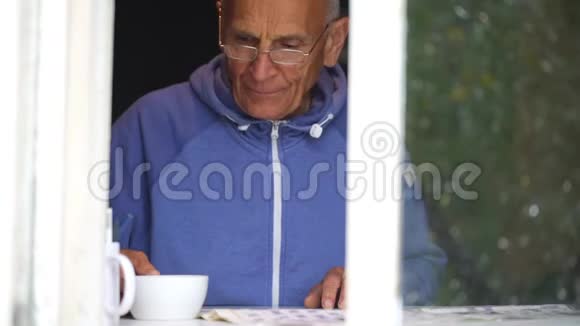 老人喝茶在窗台上读慢动作视频的预览图