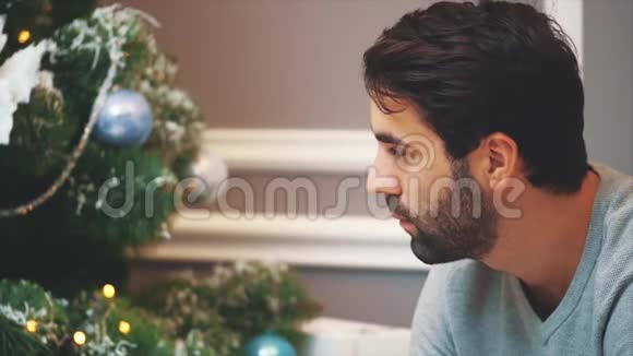 特写高清视频的胡须男子看圣诞树然后放弃拇指的相机视频的预览图