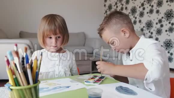 两个孩子拿着画笔在家画画的肖像视频的预览图