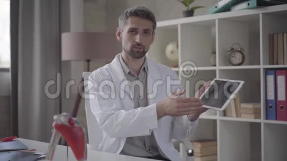 一幅身穿白色长袍的英俊男子在镜头中的画像上面显示了一张X光肺的照片技能视频的预览图