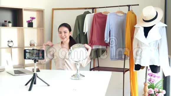 4k视频吸引人的年轻时尚博客坐在镜头前在展厅录制关于时尚和服装的视频视频的预览图