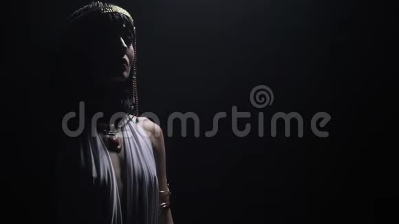 克利奥帕特拉戴着五颜六色宝石首饰站在戏剧灯光下视频的预览图