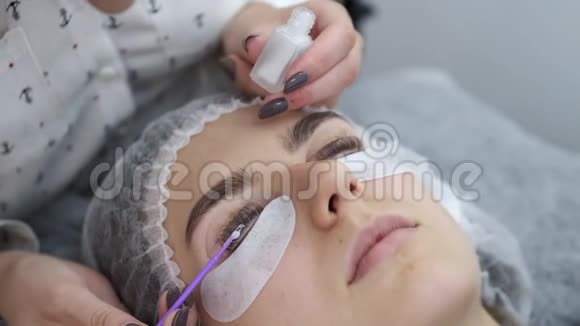 睫毛艺术家正把睫毛胶同样地涂在睫毛上视频的预览图