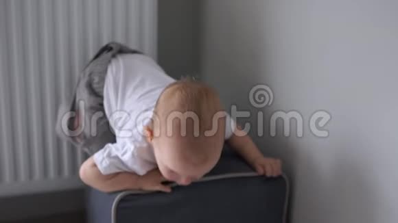 一岁半的宝宝爬上凳子跳下来一个穿白色T恤的孩子的肖像快乐的童年视频的预览图