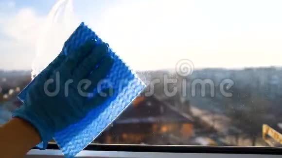 员工用微纤维布擦拭窗户以防止灰尘接触橡胶防护手套视频的预览图