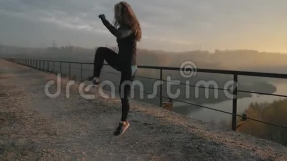 活跃的女人在大自然中锻炼和跳跃有吸引力的适合女孩的训练在早上户外热身健康视频的预览图