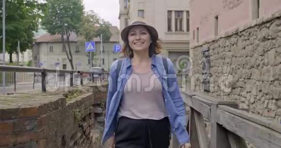 微笑的中年妇女走在一个古老的旅游城镇视频的预览图