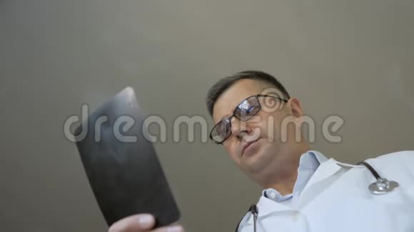 一位有经验的医生看着病人脚x光视频的预览图