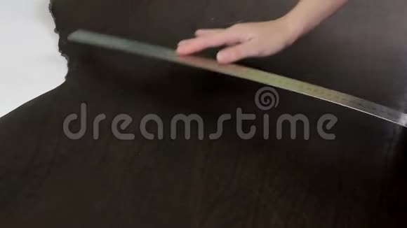 女性用金属尺子特写测量棕色皮革手工制作视频的预览图
