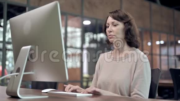 生病的老妇人在电脑工作时咳嗽视频的预览图