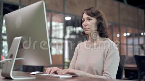背痛不舒服的老女人在电脑上工作视频的预览图