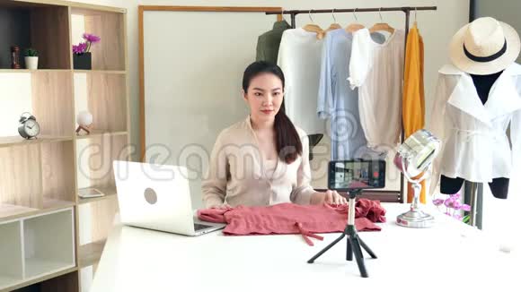 4k视频吸引人的年轻时尚博客坐在镜头前在展厅录制关于时尚和服装的视频视频的预览图