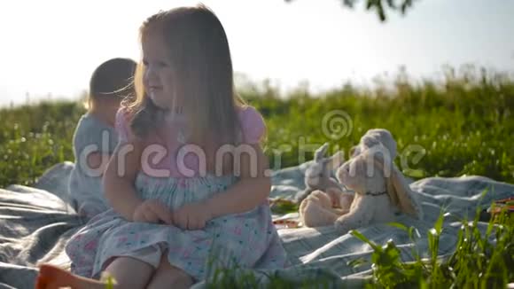 两个孩子姐妹正坐在野餐的封面上视频的预览图