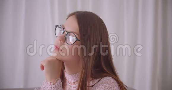 年轻漂亮的白种人女性戴着眼镜看着镜头在公寓里开心地笑着视频的预览图