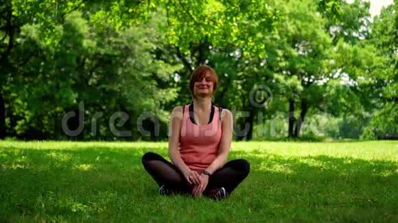 女孩坐在公园草地上的一根绳子上视频的预览图