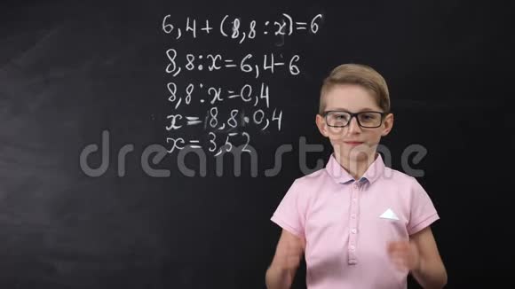 戴眼镜的可爱书呆子站在黑板旁写着数学习题视频的预览图