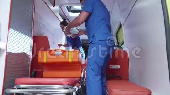 救护人员和护士把设备装在救护车里视频的预览图