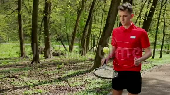 人从球拍中击打网球年轻人打网球穿着红色T恤和黑色衣服的人视频的预览图