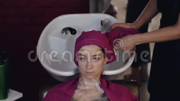 美容店洗头后头戴毛巾的顾客视频的预览图