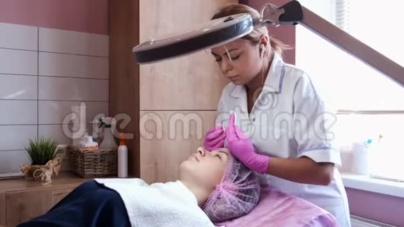 美容师用棉垫擦拭年轻女人的脸视频的预览图