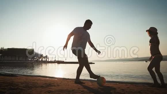 夏天一家人在海滩上踢足球父亲和女儿在户外踢足球友好的概念视频的预览图