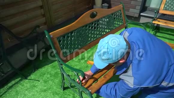 穿蓝色衣服的领班把院子里的木凳连接起来视频的预览图