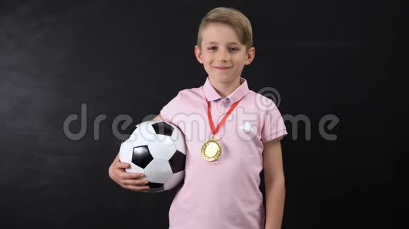 有球和奖牌的男孩站在黑板旁边足球比赛的获胜者视频的预览图