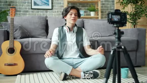 英俊的少年在家中为网络vlog播放竖起大拇指的录音录像视频的预览图