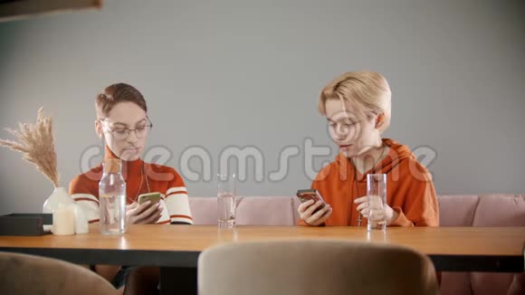 两个女孩坐在电话里互相交谈视频的预览图