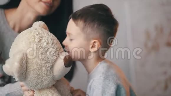 可爱的家人妈妈和儿子正在和玩具熊接吻视频的预览图