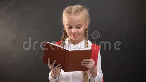 快乐的女孩子读书在相机上微笑教育爱上学视频的预览图