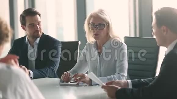 成熟的女性领导人与男性商业伙伴在谈判桌上握手视频的预览图
