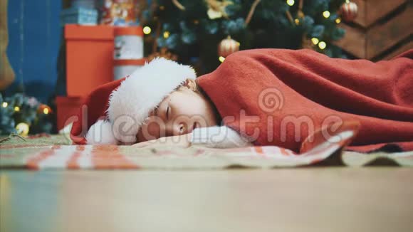 一只圣诞老人的手在一个女孩睡觉时把一个礼品盒放在她身边视频的预览图