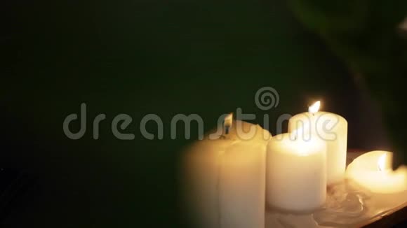 在黑暗的房间里蜡烛在木盘上燃烧视频的预览图