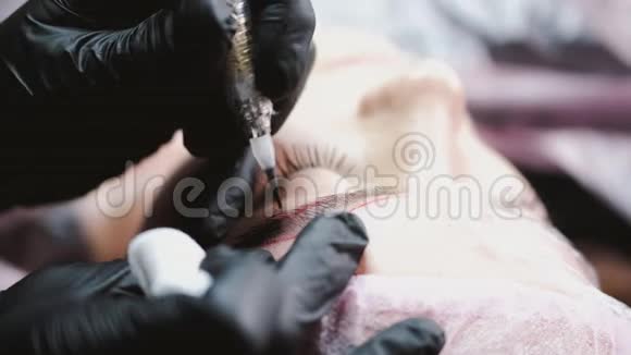 戴着橡胶手套的美容师正在用微刃技术把客户的眉毛弄得奄奄一息视频的预览图