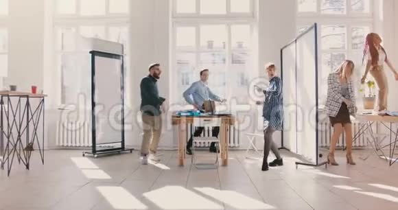 有趣的商人在轻盈的现代办公室跳舞多民族健康的工作场所团队庆祝成功慢动作视频的预览图