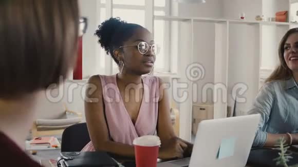 快乐的非裔美国女员工坐在桌边参加团队会议现代办公室4K的多种族团队合作视频的预览图