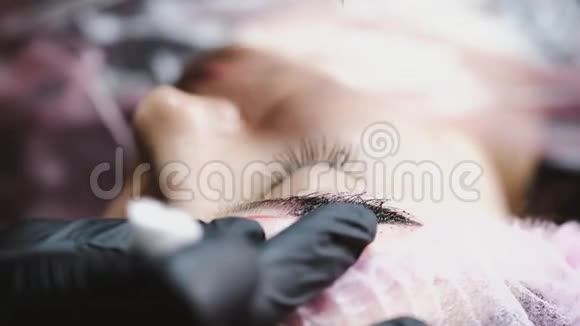 戴着橡胶手套的美容师正在用微刃技术把客户的眉毛弄得奄奄一息视频的预览图