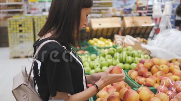年轻女子在超市买苹果视频的预览图