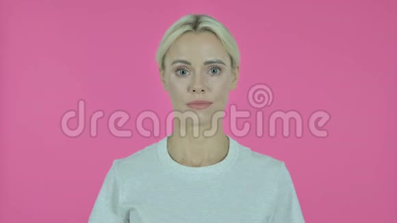 粉红背景下年轻女子的胜利标志视频的预览图