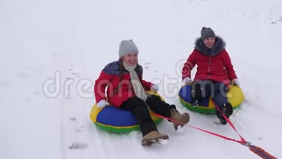 孩子们在冬天雪橇青少年在冬季公园玩圣诞假期快乐童年的概念开心快乐视频的预览图