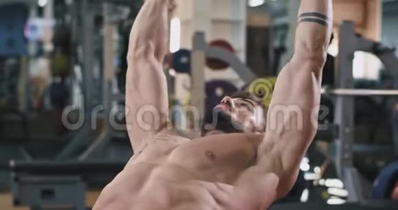 一个健身房的人正在做大量的举重运动同时锻炼他的肌肉让他们获得完美的腹肌视频的预览图