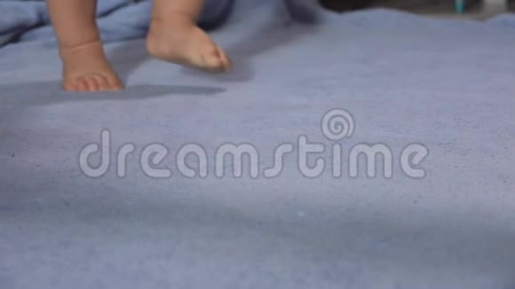可爱的孩子们用蓝色的毯子脚趾头走路视频的预览图